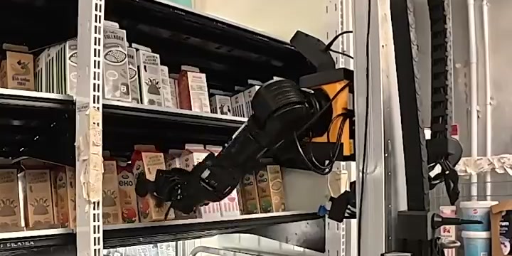 A Cota robot's arm reaching into a chilled shelf at ICA Nära Roslagstull